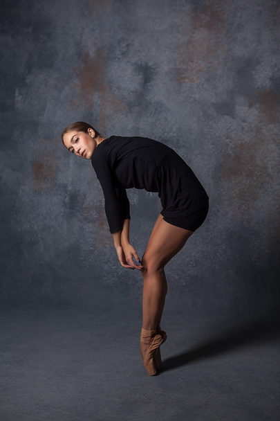 Young beautiful modern style dancer posing on a studio background - Foto, Bild