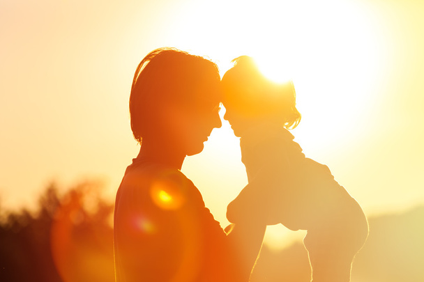 Isä ja pieni tytär siluetteja auringonlaskun aikaan
 - Valokuva, kuva