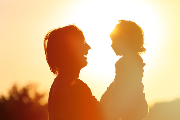 Édesapja és a kis lánya sziluettek a naplemente - Fotó, kép