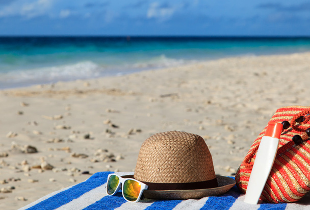 капелюх, сумка, сонцезахисні окуляри на тропічному пляжі
 - Фото, зображення