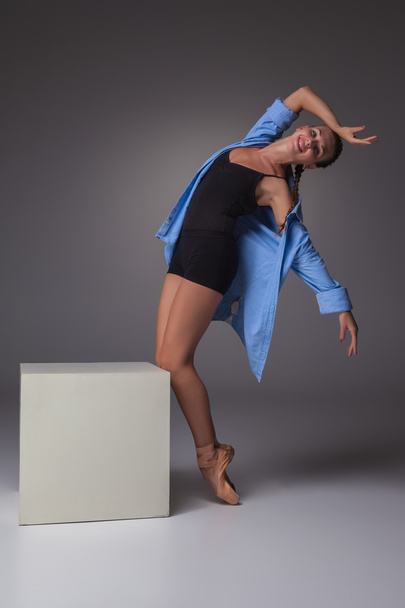 Young beautiful modern style dancer posing on a studio background - Foto, Imagen
