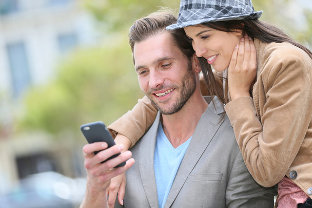 couple in town using smartphone - Foto, afbeelding