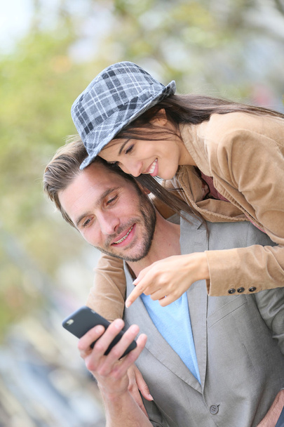 couple in town using smartphone - Fotó, kép