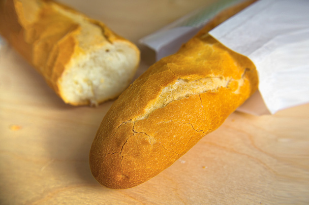 Pitkä leipä ranskalainen patonki puinen pöytä
 - Valokuva, kuva