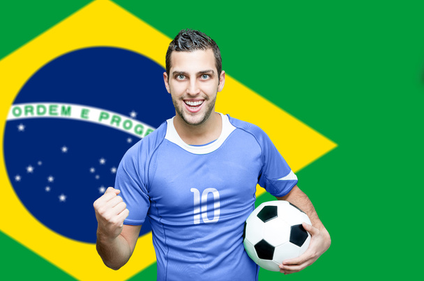 Ventilator viert op Brazilië vlag achtergrond - Foto, afbeelding