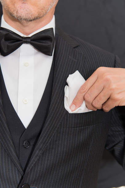 Gentleman In zwarte stropdas corrigeert zak plein, verticaal - Foto, afbeelding