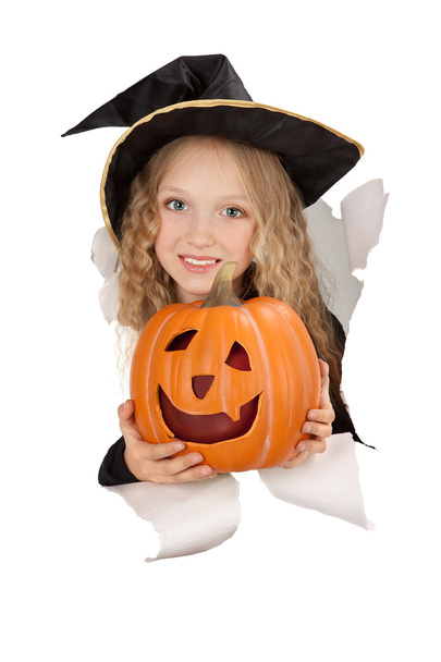 Breakthrough little witch holding a pumpkin - Foto, immagini