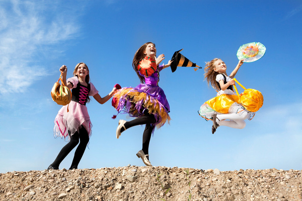 Trois petites sorcières mignonnes sautant avec des sacs
 - Photo, image
