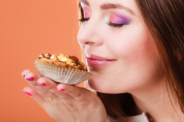 woman closed eyes holds cake in hand - Foto, imagen