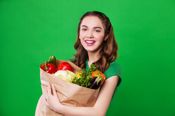 młoda kobieta uśmiechający się trzymając torbę, pełnego zdrowej żywności. zakupy - Zdjęcie, obraz