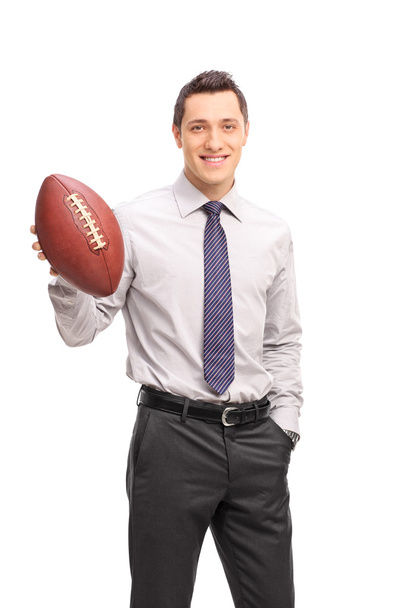 Young businessman holding an American football - Foto, immagini
