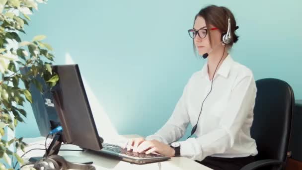 Woman in call center smilingly looking at the camera - Footage, Video