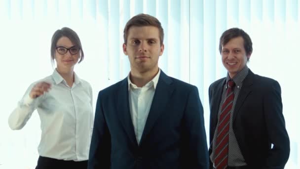 Team aus drei erfolgreichen Geschäftsleuten blickt in die Kamera - Filmmaterial, Video