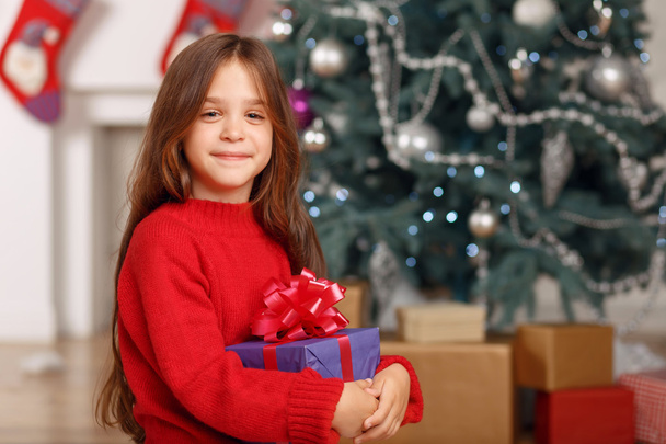 Nice girl playing near Christmas tree - Zdjęcie, obraz
