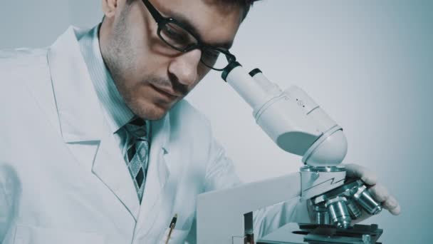 Junge Ärztin schaut durchs Mikroskop - Filmmaterial, Video