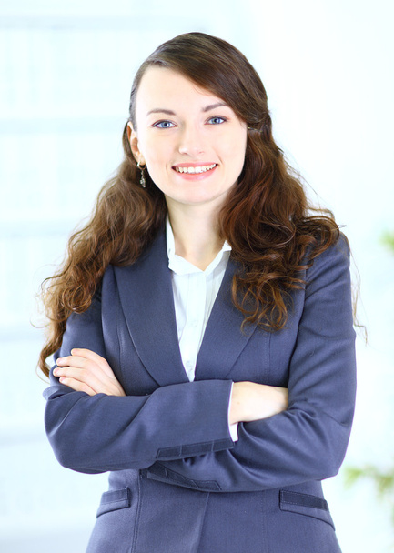 Portrait of a cute young business woman smiling, in an office environment - Foto, Imagem