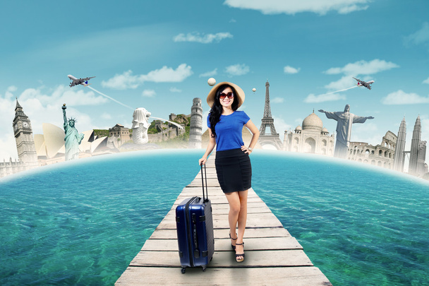Gorgeous traveler carrying luggage on the jetty - Zdjęcie, obraz
