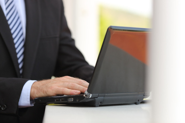 Üzleti ember kéz használ egy laptop, az utcán - Fotó, kép