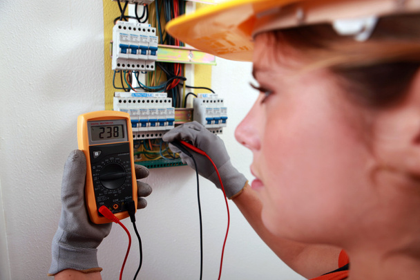 An electrician using a multimeter - 写真・画像