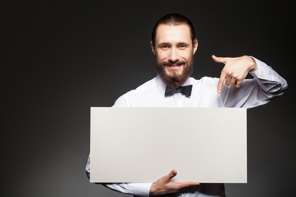 Attractive young guy with beard is carrying placard - Φωτογραφία, εικόνα