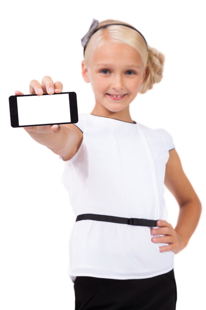 Schoolgirl with mobile phone in hand looking at the camera and s - Photo, image