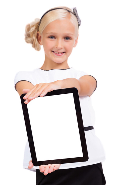 school girl with a tablet in hands looking at the camera and smi - Foto, Imagen