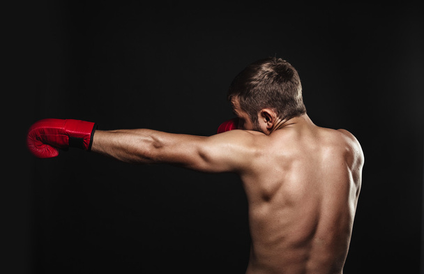 Athletic bearded boxer with gloves on a dark background - Fotografie, Obrázek