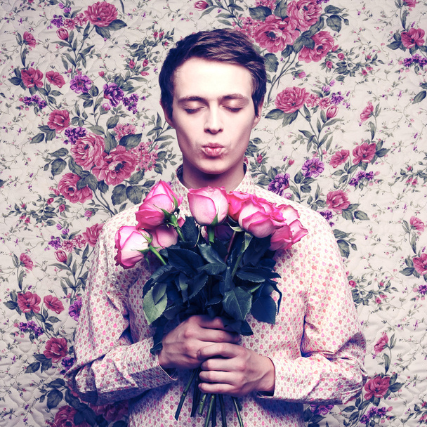 Young beautiful man with flowers - Фото, зображення