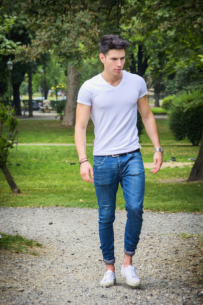 Handsome young man in white t-shirt outdoor in city park - Photo, image