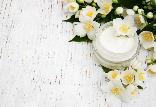 gezicht en lichaam crème moisturizers met jasmijn bloemen - Foto, afbeelding
