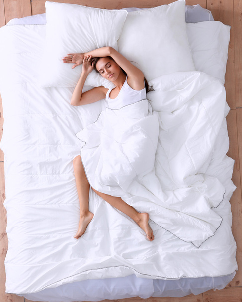 Young beautiful woman lying in bed - Foto, Imagen