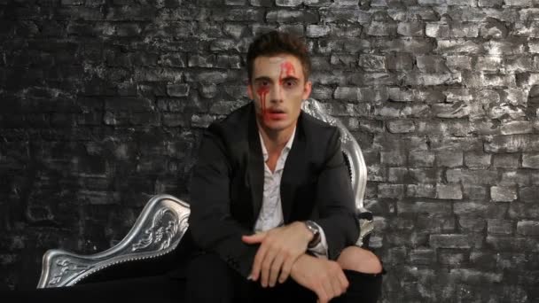 Homem vampiro sentado em um sofá preto
 - Filmagem, Vídeo