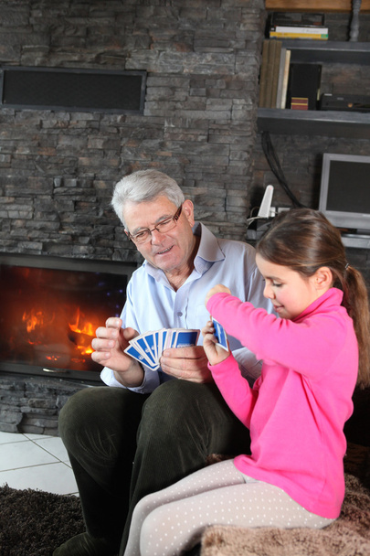 Little girl playing card game with granddad - Foto, afbeelding