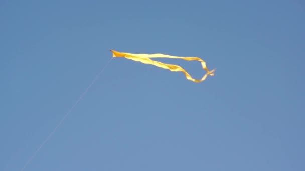 Mavi gökyüzünde uçan bir sarı uçurtma - Video, Çekim