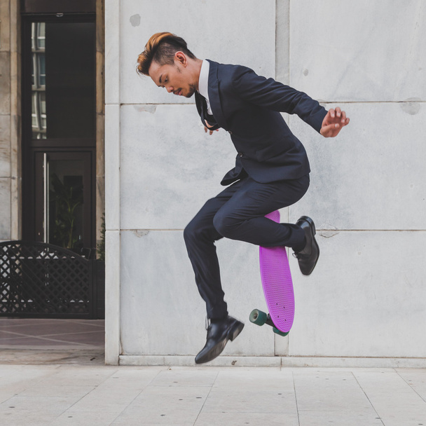 Young handsome Asian model jumping with his skateboard - Fotoğraf, Görsel