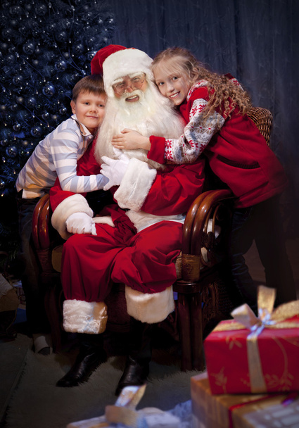 Classic Santa giving Christmas Presents to Happy Children. - Photo, Image