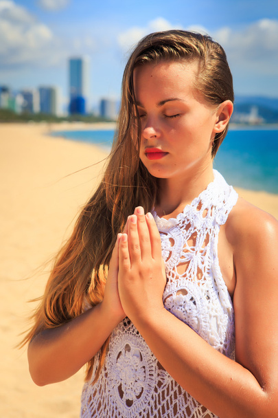 meisje praktizerende yoga op het strand - Foto, afbeelding