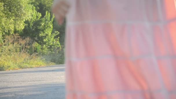 chica en un vestido rosa va en el camino
 - Imágenes, Vídeo