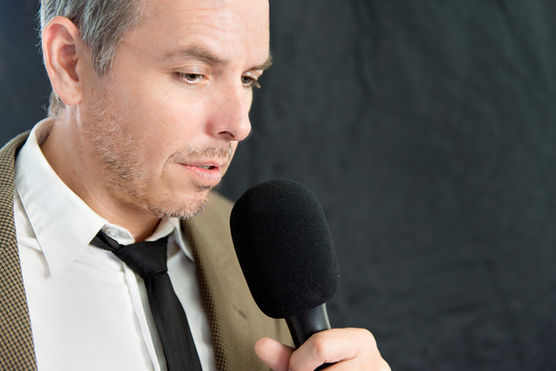 Ernsthafter Mann spricht ins Mikrofon - Foto, Bild