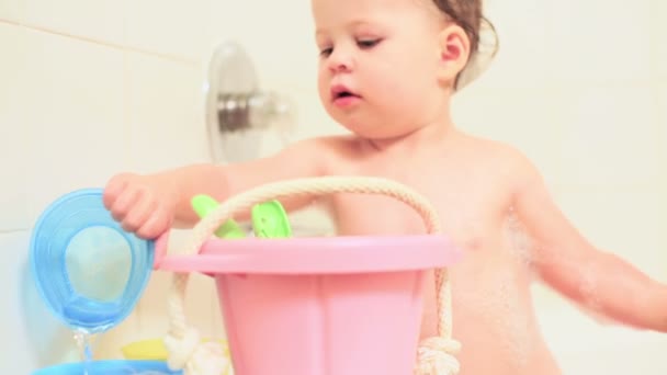 kleines Mädchen badet in einer Badewanne mit Spielzeug - Filmmaterial, Video
