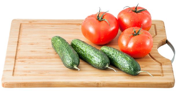 cucumbers and tomatoes on a cutting board - Foto, afbeelding