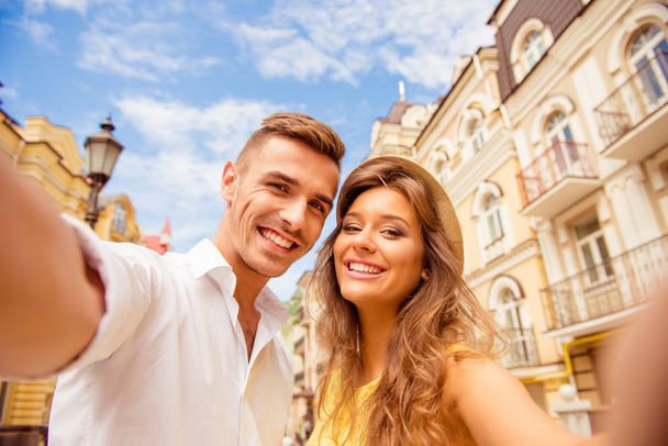 couple making selfie photo on a background of the city - Фото, изображение
