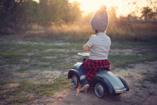 Açık havada oyuncak araba ile oynarken yürümeye başlayan çocuk - Fotoğraf, Görsel