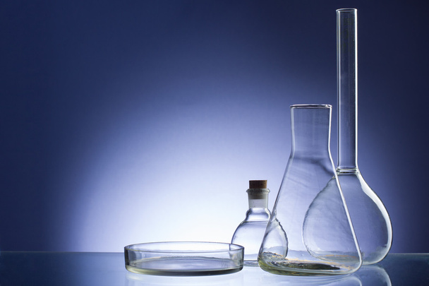 Assorted empty laboratory glassware, test-tubes. Blue tone medical background. Copy space - Photo, Image