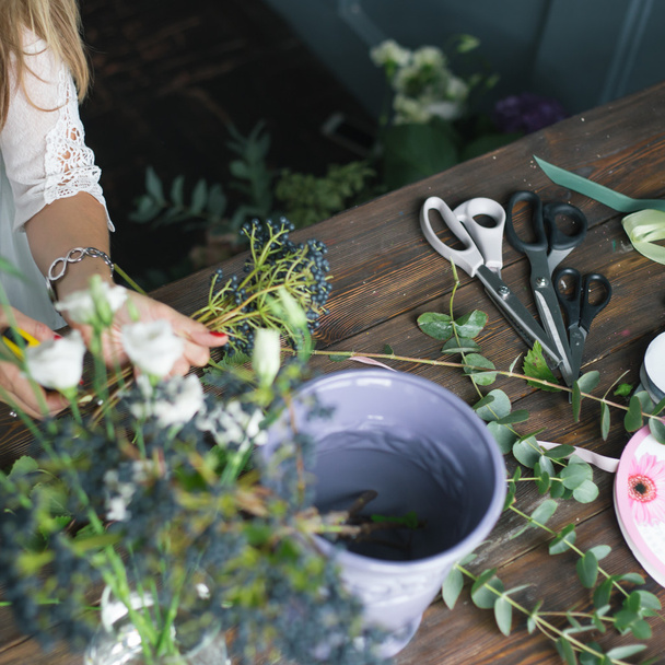 Florist workplace: flowers and accessories on a vintage wooden table. soft focus - Фото, изображение