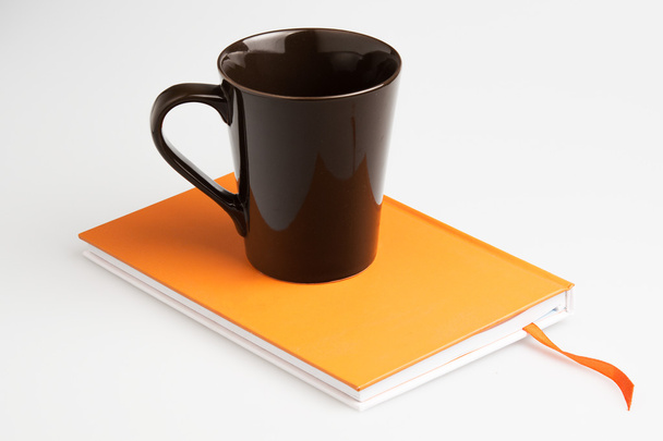 Orange note book white pen and cup - Фото, зображення