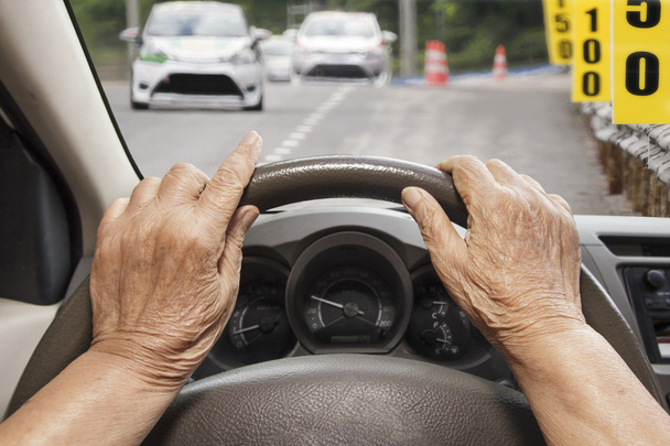 Senior woman driving a car on road. - Foto, afbeelding