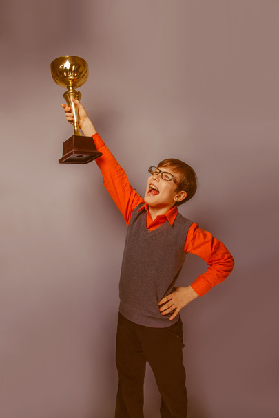 European-looking  boy of  ten  years in glasses  holding a cup a - Φωτογραφία, εικόνα