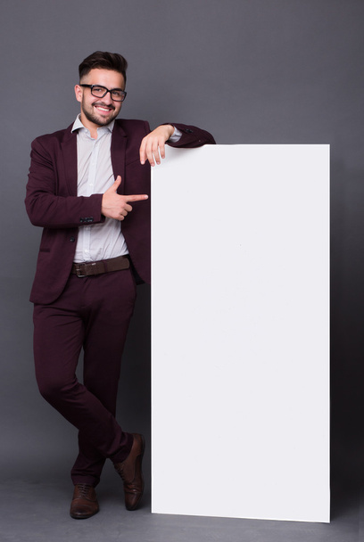 Hipster man in business suit with blank poster - Foto, imagen