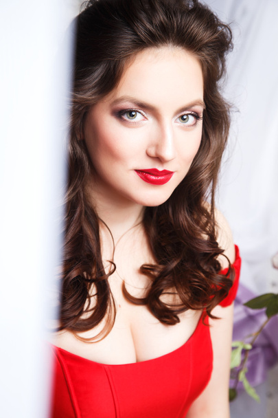 Close-up portrait of beautiful brunette young woman in elegant luxury red dress - Фото, изображение
